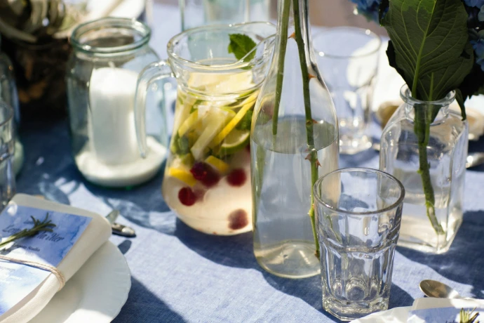 a table topped with glasses and vases filled with flowers